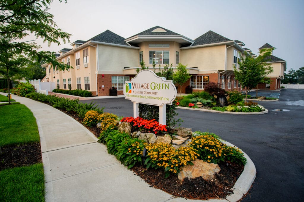 A sign displaying Village Green's assisted living facility