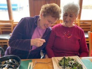 A picture of two women smiling over a meal