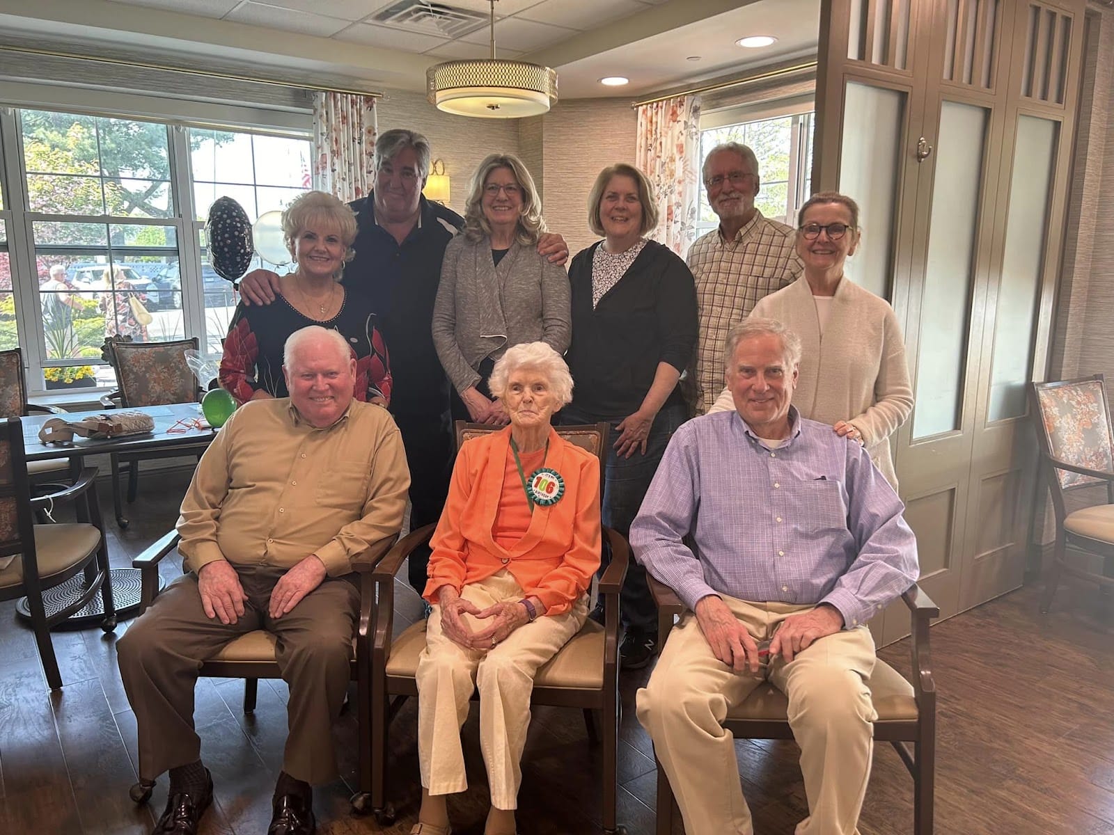 A senior citizen celebrating her 100th birthday with family members next to her