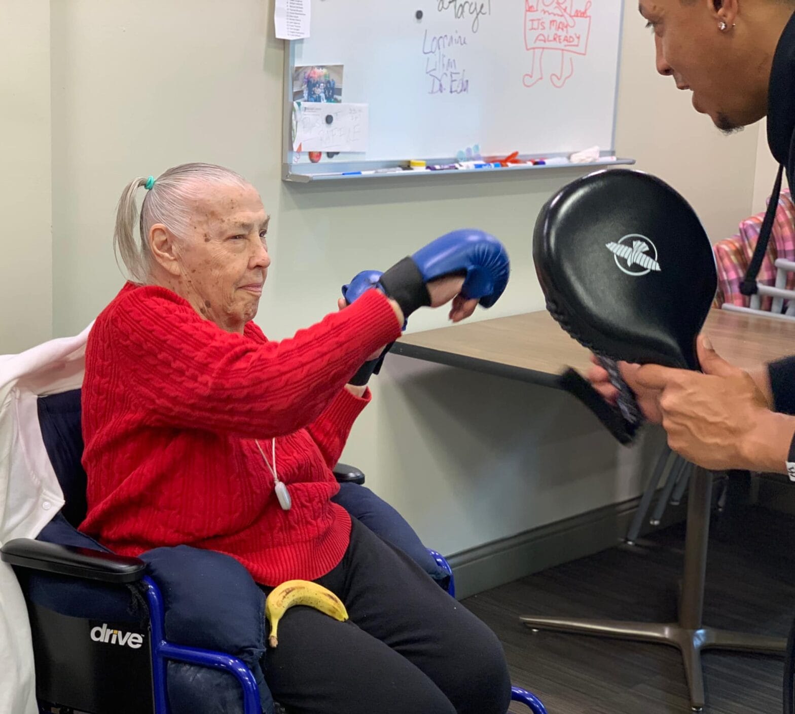 A woman boxing against a person holding a boxing glove