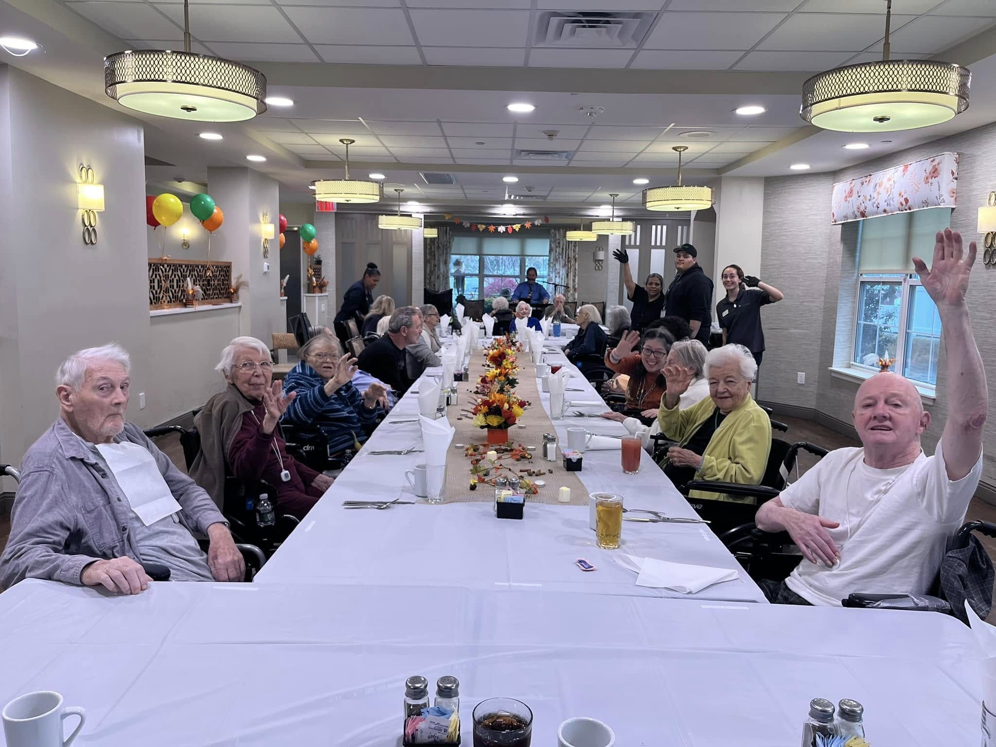 Residents sitting at a Thanksgiving table in a memory care facility