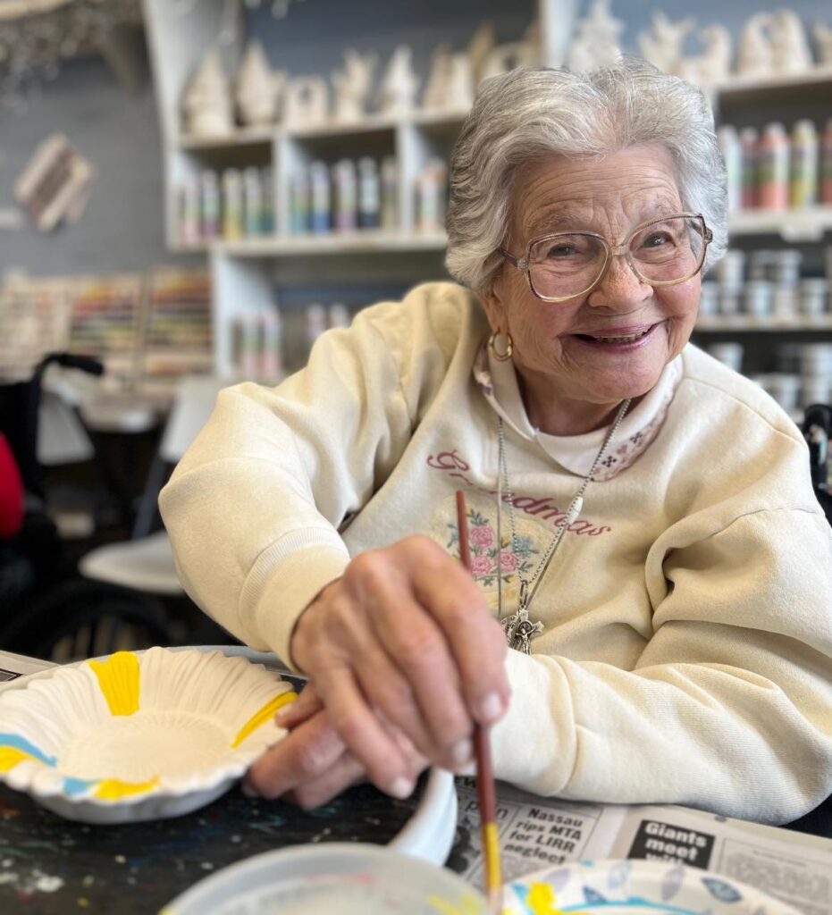A person in a dementia care facility smiling while painting