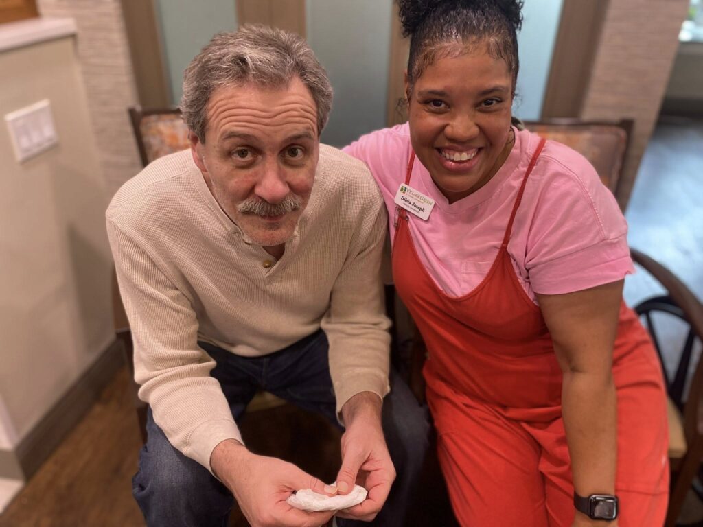 A picture of a Village Green staff member with their arm around a Village Green resident
