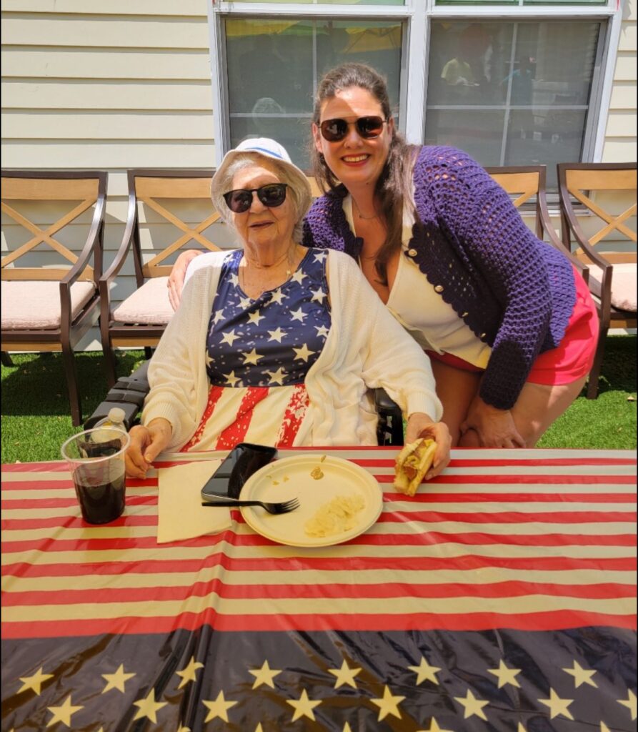 A senior citizen eating a hot dog with an American flag tablecloth